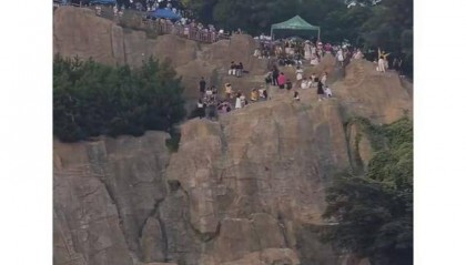 大连一跨海大桥观景台有游客翻栏杆踩空心造景石拍照，当地回应